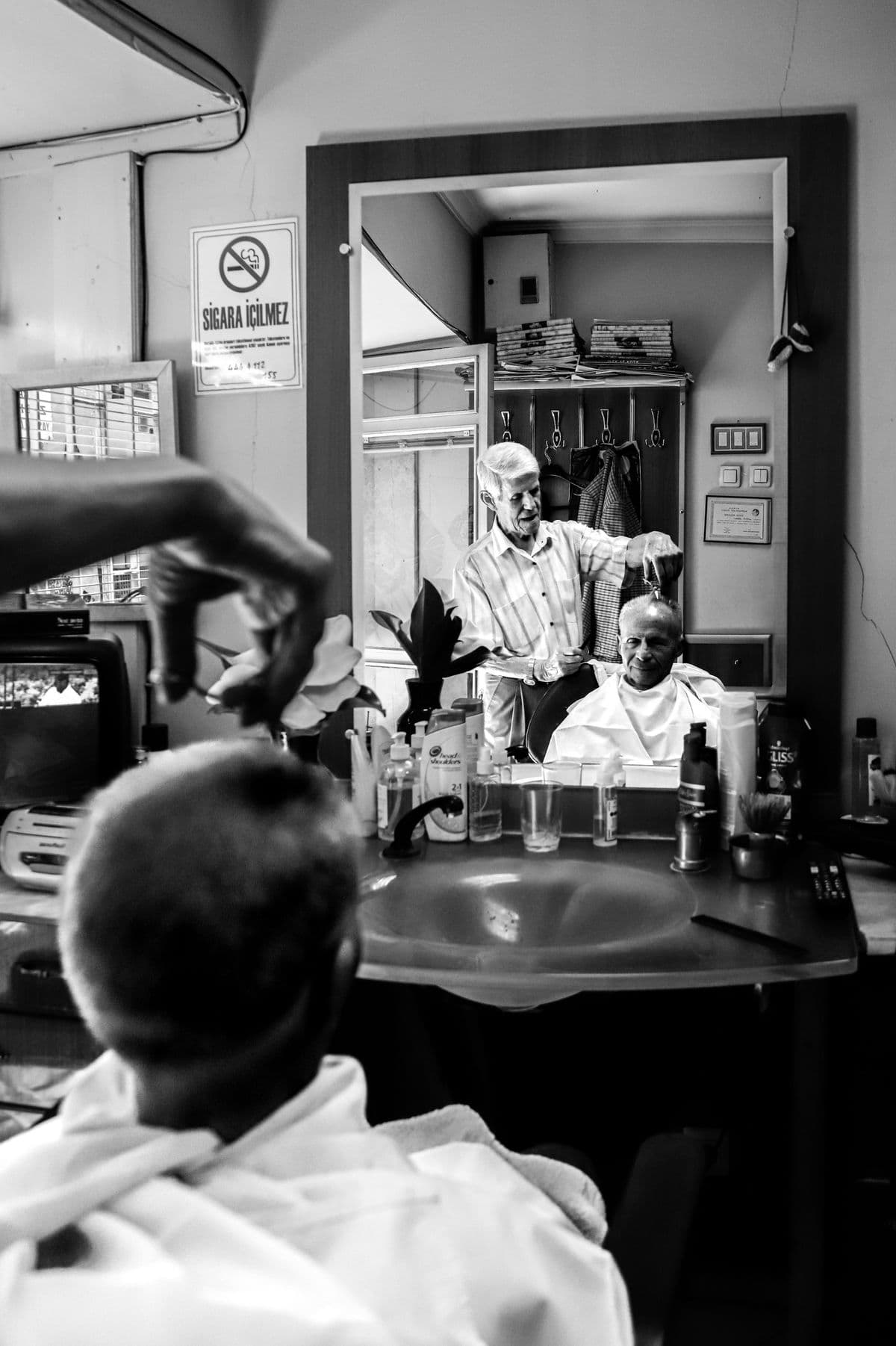 A barber mid-cut, working fast